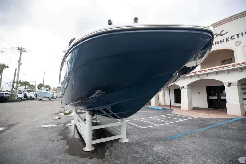 Slide: The Image of 2023 Hurricane SunDeck 2200 OB boat displayed on a stand outside a building. - 6