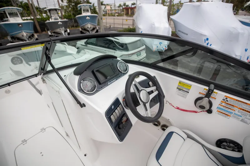 Slide: The Image of 2023 Hurricane SunDeck 2200 OB boat cockpit with steering wheel and dashboard controls. - 15