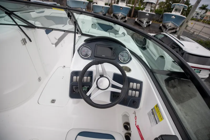 Slide: The Image of 2023 Hurricane SunDeck 2200 OB boat cockpit with steering wheel and dashboard controls. - 17