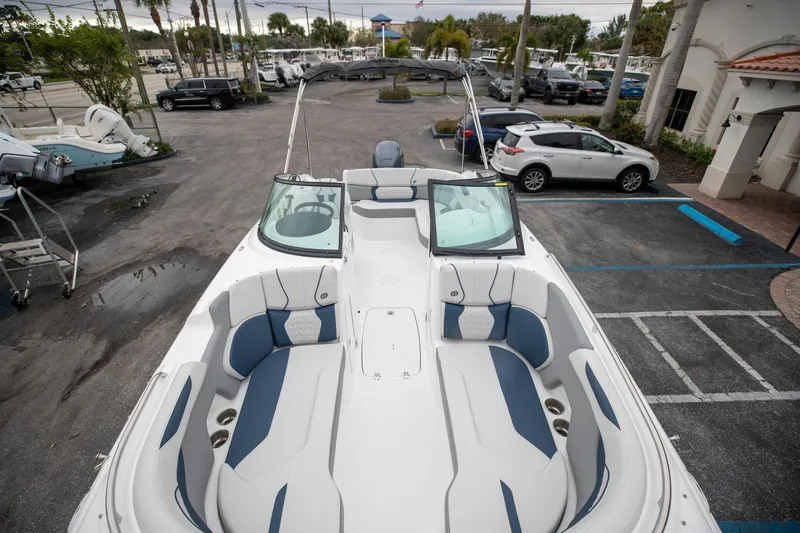 Slide: The Image of 2023 Hurricane SunDeck 2200 OB boat with spacious seating in a parking lot setting. - 18