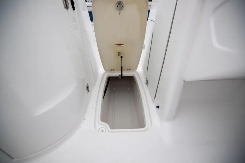 Slide: The Image of 2023 Hurricane SunDeck 2200 OB boat storage compartment open, showcasing interior space. - 21