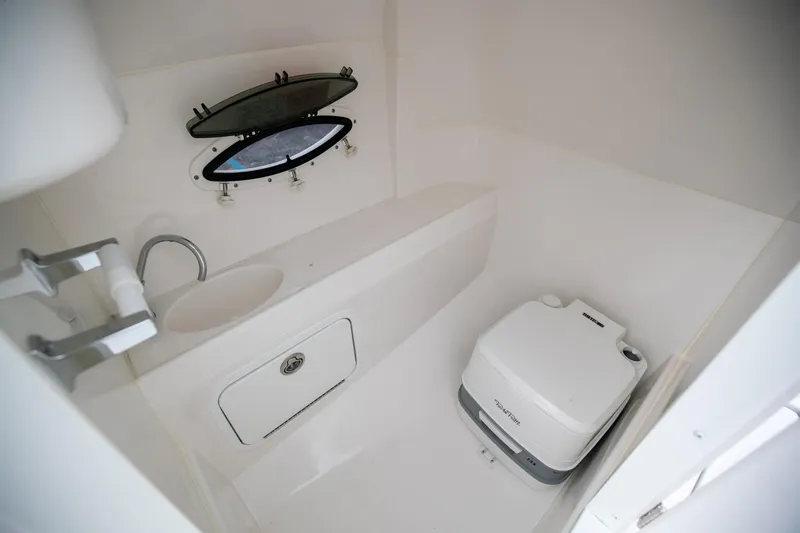 Slide: The Image of 2023 Hurricane SunDeck 2200 OB boat interior with sink and portable toilet. - 33