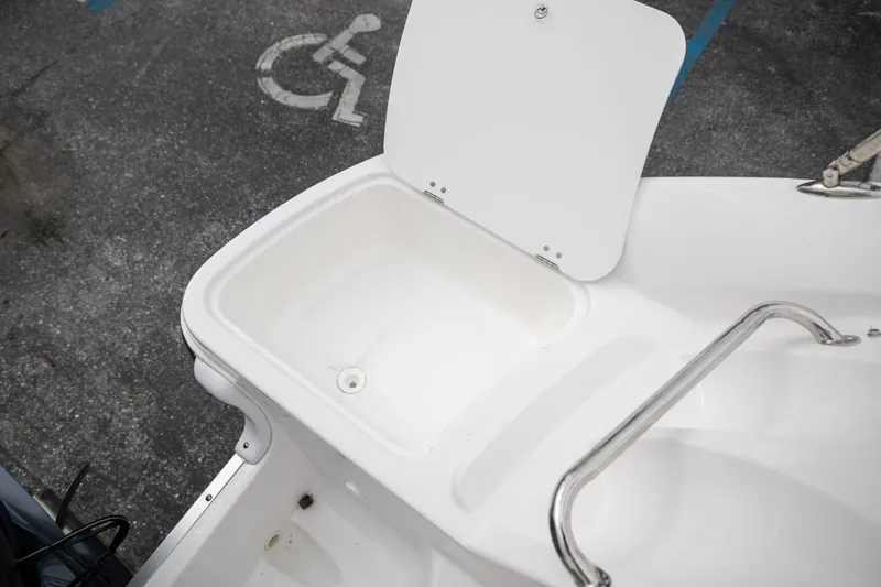 Slide: The Image of Open storage compartment on 2023 Hurricane SunDeck 2200 OB boat, with stainless steel railing. - 36