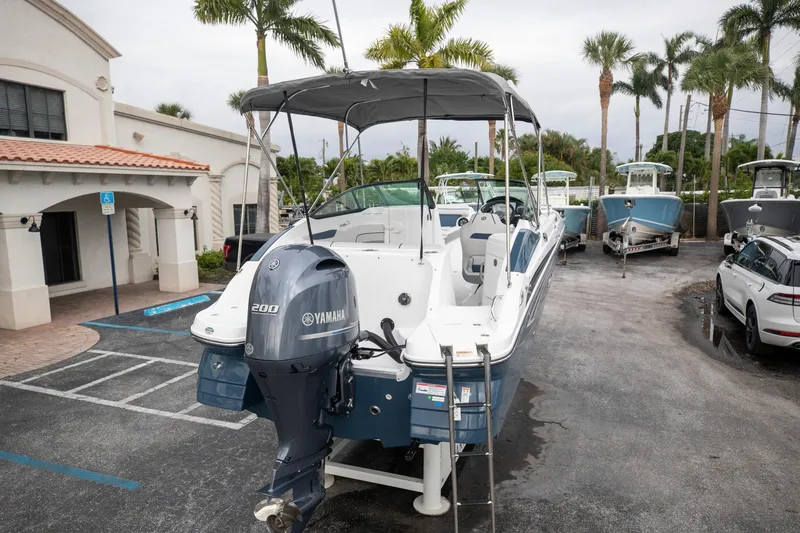 Slide: The Image of 2023 Hurricane SunDeck 2200 OB boat with Yamaha engine in a parking lot. - 4