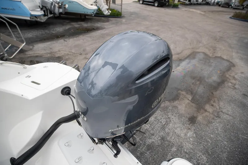 Slide: The Image of 2023 Hurricane SunDeck 2200 OB boat with a Yamaha outboard motor in a marina. - 6