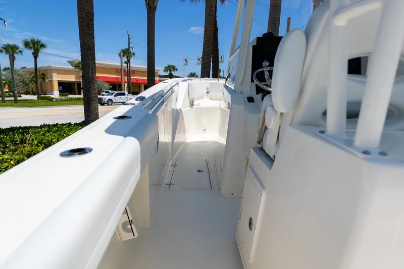 Slide: The Image of 2024 Cobia 320 CC boat interior with steering wheel and seating, sunny day. - 19