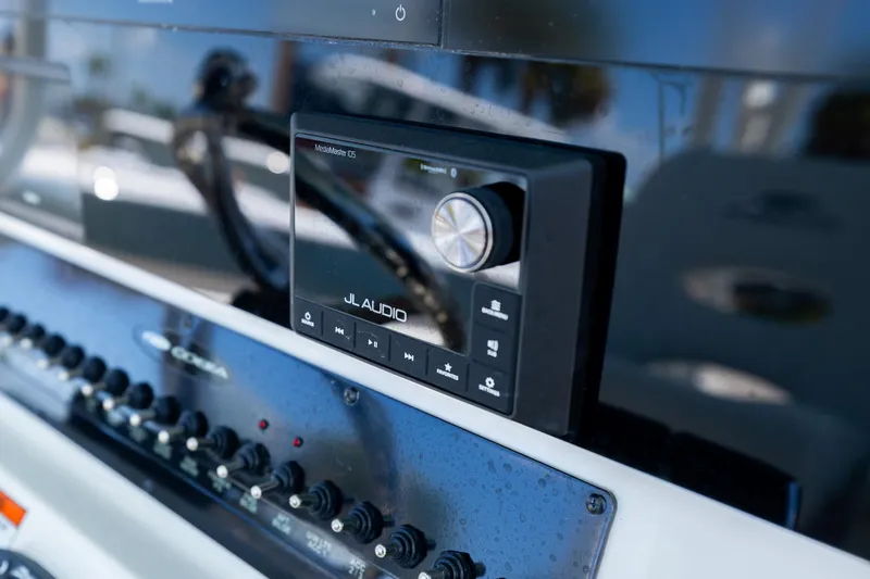 Slide: The Image of JL Audio system on 2024 Cobia 320 CC boat dashboard with control panel. - 23