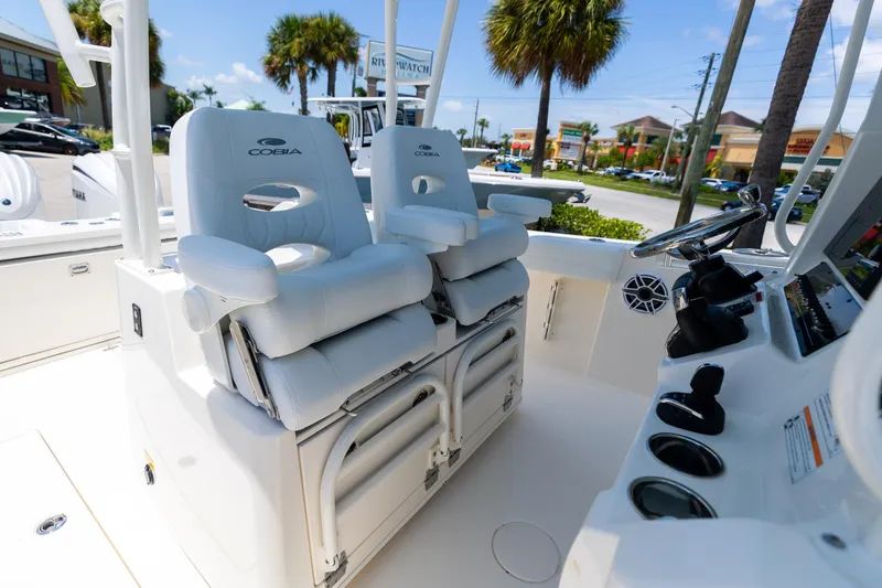 Slide: The Image of 2024 Cobia 320 CC boat interior with white cushioned seats and steering console. - 29