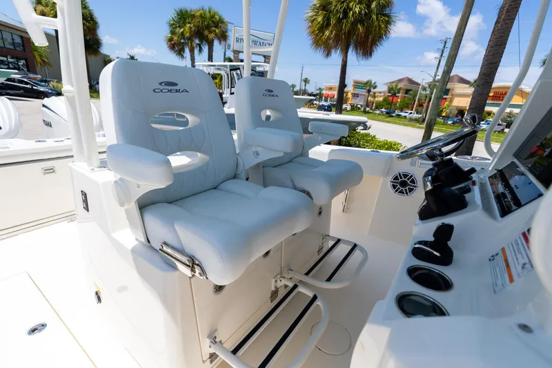 Slide: The Image of 2024 Cobia 320 CC boat interior with luxurious seating and modern controls. - 30