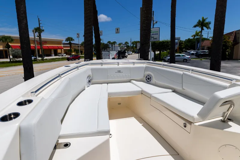 Slide: The Image of 2024 Cobia 320 CC boat with spacious white seating area under clear blue sky. - 36