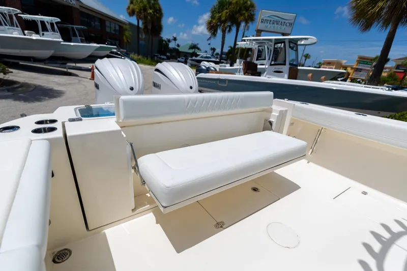 Slide: The Image of 2024 Cobia 320 CC boat with white seating and dual Yamaha engines. - 9