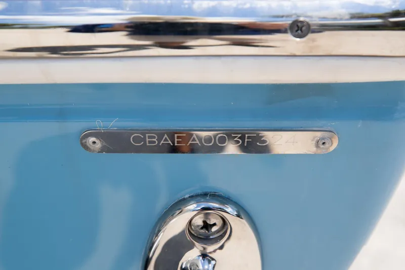 Slide: The Image of 2024 Cobia 320 CC boat hull identification number on blue surface. - 44