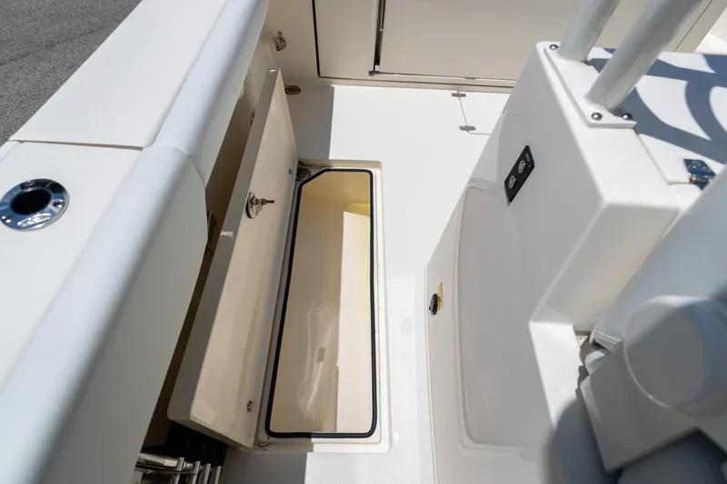 Slide: The Image of 2024 Cobia 320 CC boat storage compartment, open and empty, showcasing interior space. - 16