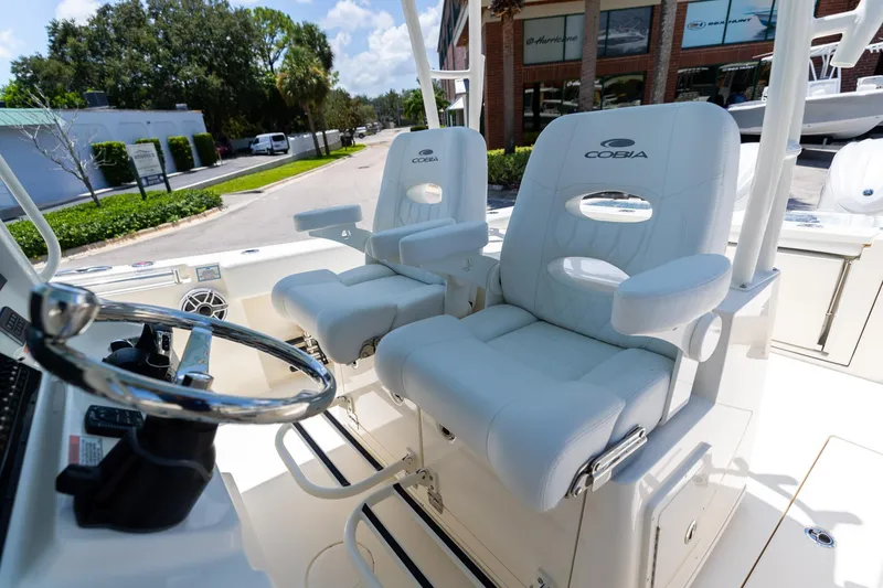 Slide: The Image of 2024 Cobia 320 CC boat interior with luxurious white seating and steering wheel. - 32