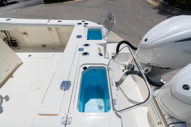 Slide: The Image of 2024 Cobia 320 CC boat deck with livewell and dual Yamaha engines. - 6