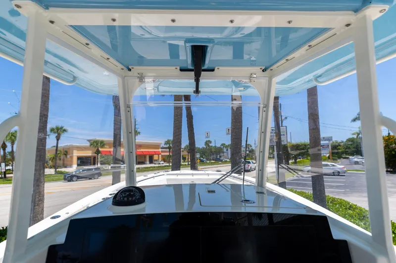 Slide: The Image of 2024 Cobia 320 CC boat interior view with clear canopy and dashboard. - 26