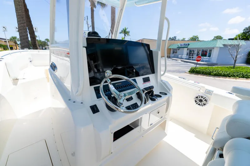 Slide: The Image of 2024 Cobia 320 CC boat helm with modern controls and steering wheel. - 28