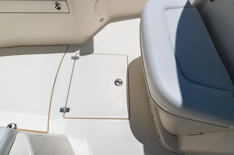 Slide: The Image of 2024 Cobia 320 CC boat interior with storage compartment and cushioned seating. - 37