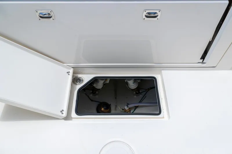 Slide: The Image of Open hatch on 2024 Cobia 320 CC boat deck, revealing internal components. - 11