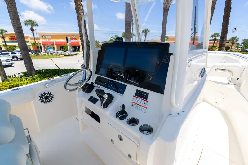 Slide: The Image of 2024 Cobia 320 CC boat cockpit with modern controls and steering wheel. - 20