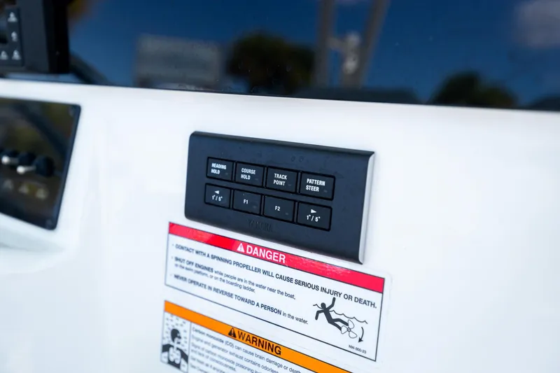 Slide: The Image of Control panel on 2024 Cobia 320 CC boat with warning labels. - 22