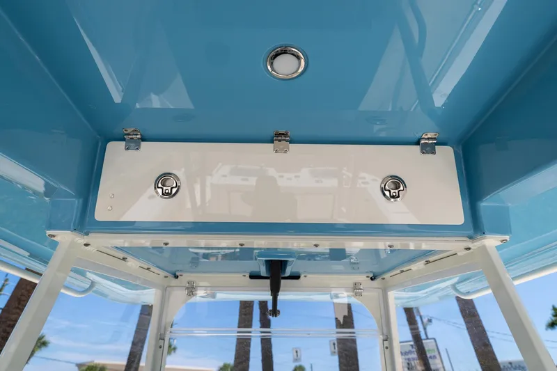 Slide: The Image of 2024 Cobia 320 CC boat interior with blue ceiling and storage compartment. - 27