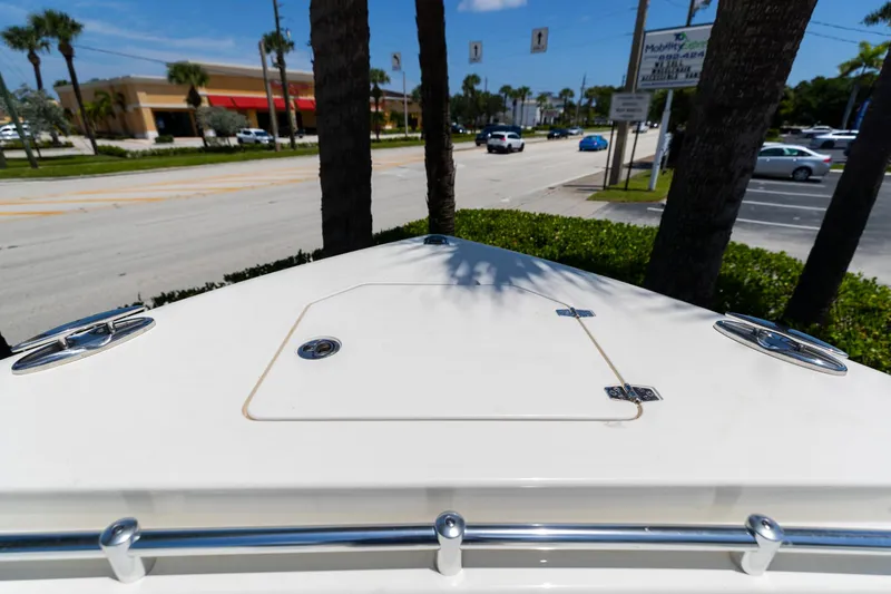 Slide: The Image of Bow view of 2024 Cobia 320 CC boat near a busy street with palm trees. - 39