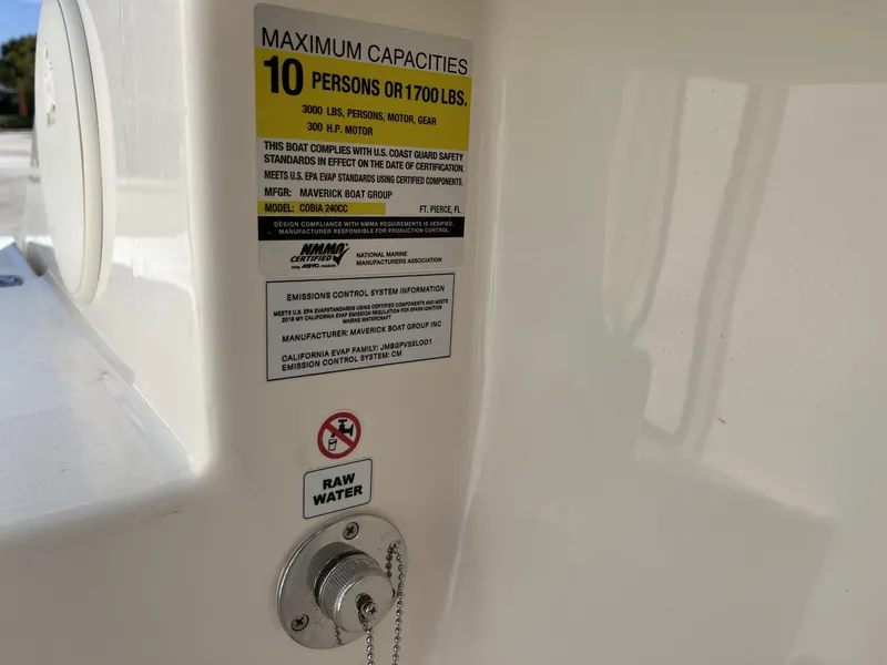 Slide: The Image of Capacity label on 2024 Cobia 240 CC boat, showing maximum weight and passenger limits. - 23