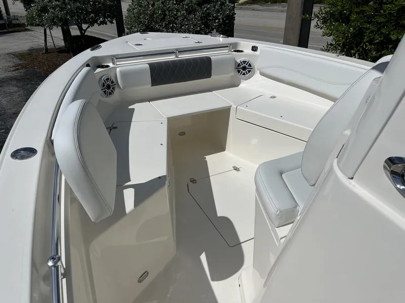 Slide: The Image of 2024 Cobia 240 CC boat interior with white seating and storage compartments. - 13