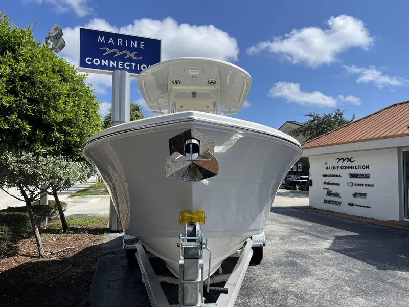 Slide: The Image of 2024 Cobia 240 CC boat at Marine Connection dealership under a clear blue sky. - 3