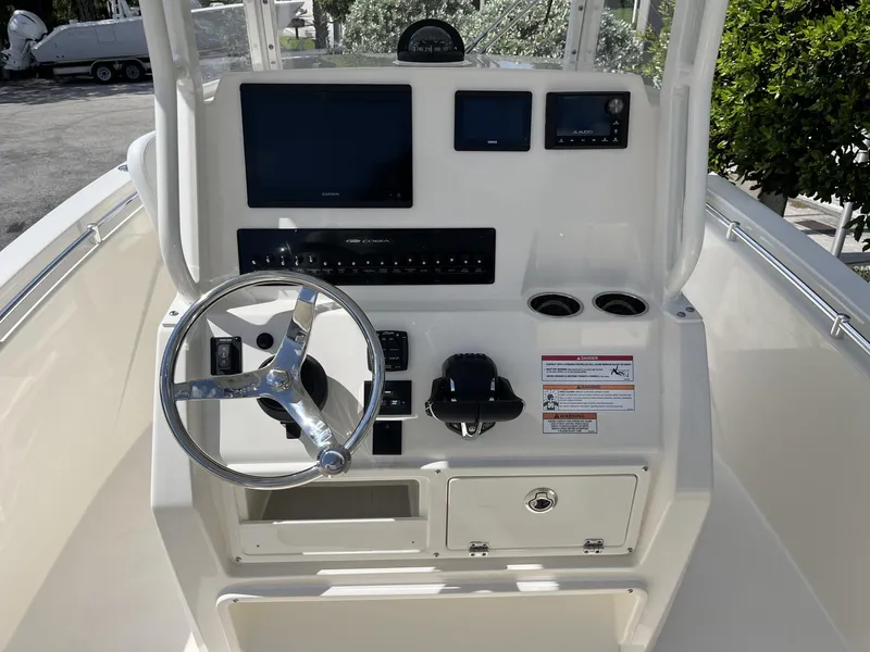 Slide: The Image of 2024 Cobia 240 CC boat console with steering wheel and electronic displays. - 11