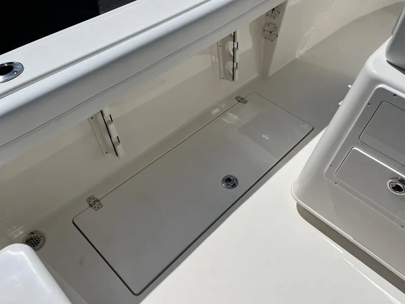 Slide: The Image of 2024 Cobia 240 CC boat interior with storage compartments and sleek design. - 27