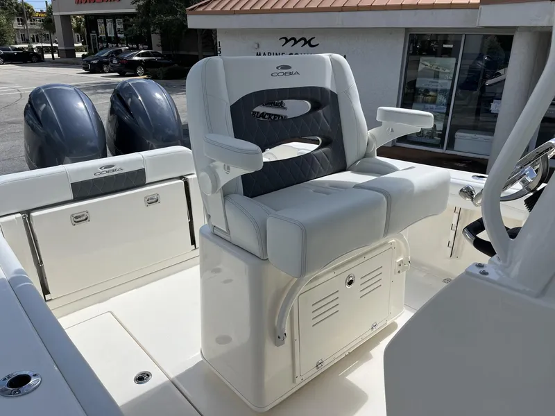 Slide: The Image of 2024 Cobia 240 CC boat interior with dual engines and cushioned seating. - 20