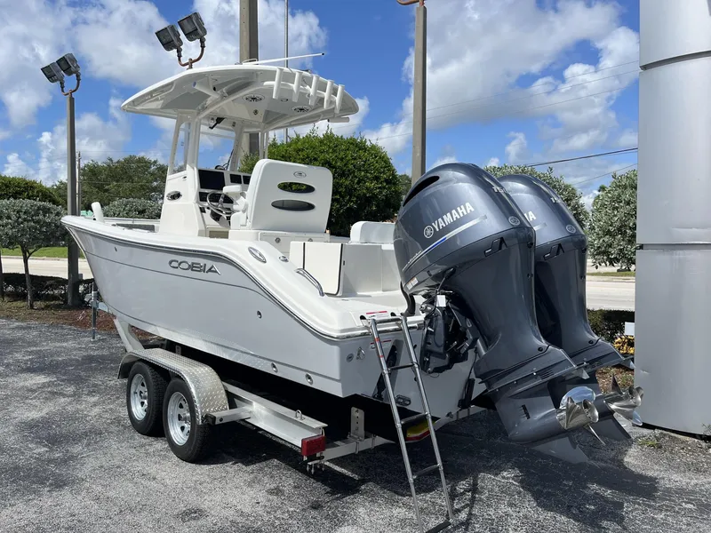 Slide: The Image of 2024 Cobia 240 CC boat with dual Yamaha engines on a trailer. - 4