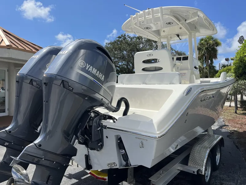 Slide: The Image of 2024 Cobia 240 CC boat with dual Yamaha engines on a trailer, under a clear blue sky. - 6