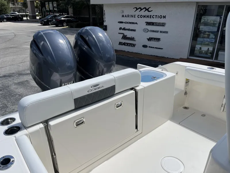 Slide: The Image of 2024 Cobia 240 CC boat with dual engines at Marine Connection dealership. - 21