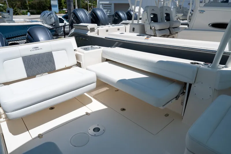Slide: The Image of 2024 Cobia 280 DC boat interior with white seating and multiple outboard engines. - 16