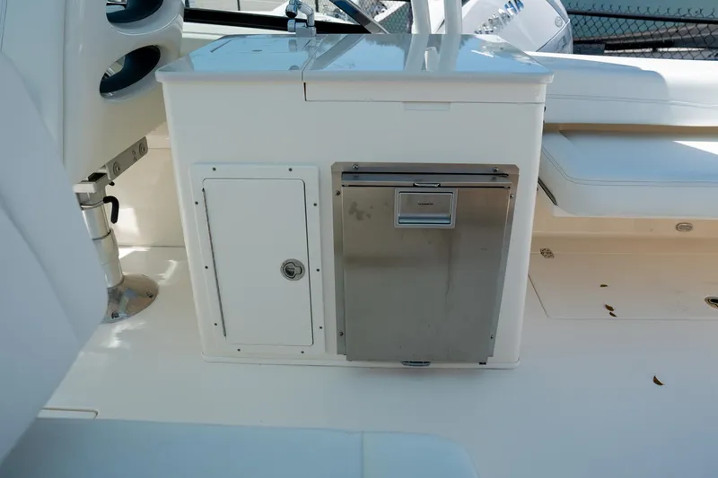 Slide: The Image of 2024 Cobia 280 DC boat interior with storage compartment and stainless steel appliance. - 17