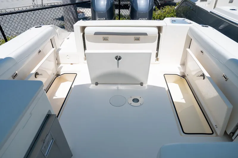 Slide: The Image of 2024 Cobia 280 DC boat interior with storage compartments and dual engines. - 20