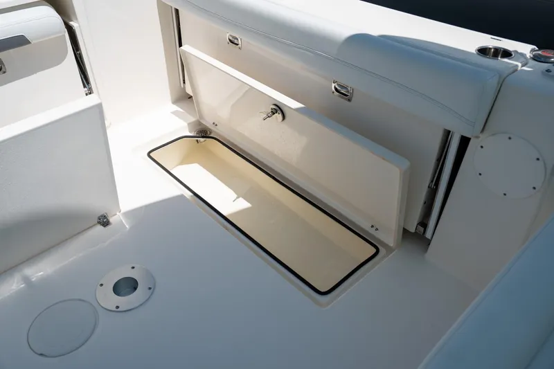 Slide: The Image of 2024 Cobia 280 DC boat storage compartment with open hatch, showcasing interior space. - 21