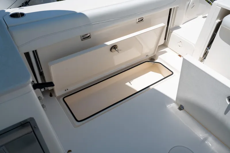 Slide: The Image of 2024 Cobia 280 DC boat storage compartment with open hatch, showcasing interior space. - 22