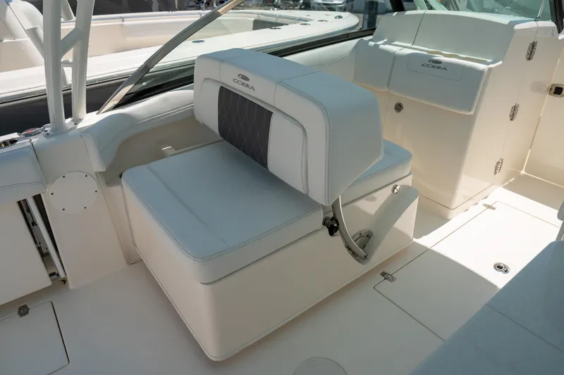 Slide: The Image of 2024 Cobia 280 DC boat interior with white seating and storage compartments. - 24