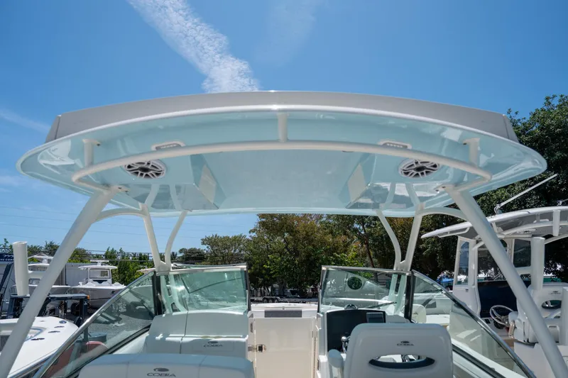 Slide: The Image of 2024 Cobia 280 DC boat with sleek design and modern features under a clear blue sky. - 26
