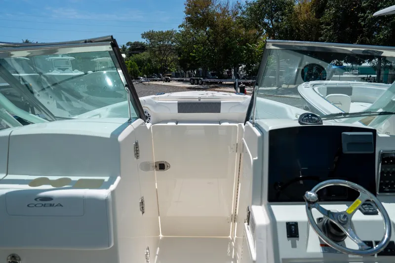Slide: The Image of 2024 Cobia 280 DC boat interior with steering wheel and open deck view. - 27