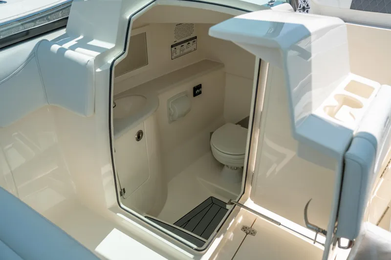 Slide: The Image of 2024 Cobia 280 DC boat interior with compact bathroom and modern amenities. - 28