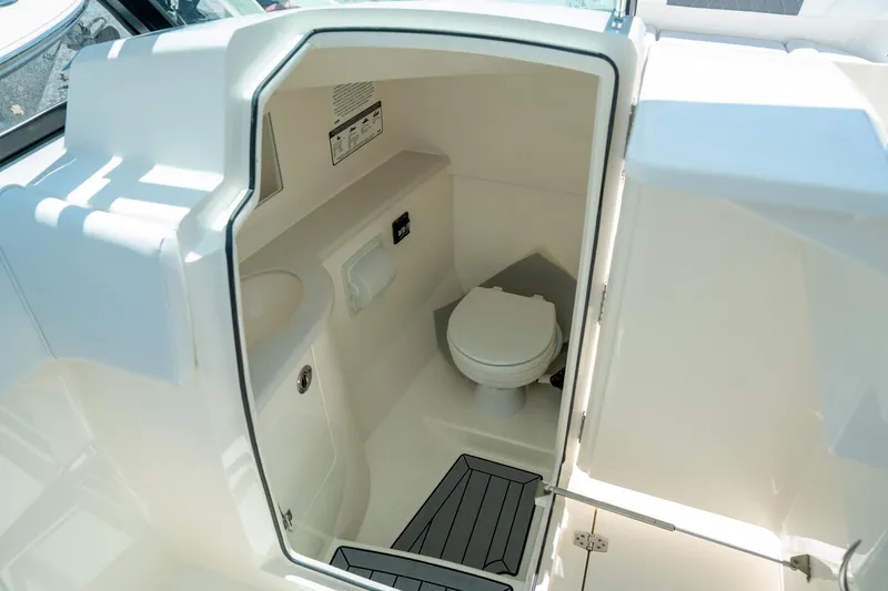 Slide: The Image of 2024 Cobia 280 DC boat interior bathroom with toilet and sink. - 29