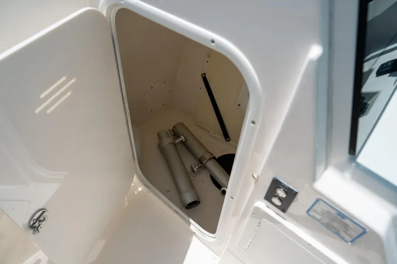 Slide: The Image of Open storage compartment on 2024 Cobia 280 DC boat, showing interior space and equipment. - 31