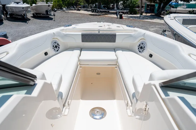 Slide: The Image of 2024 Cobia 280 DC boat interior with white seating and speakers. - 32