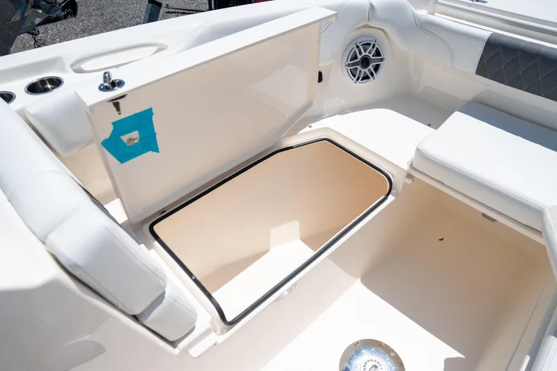 Slide: The Image of 2024 Cobia 280 DC boat interior storage compartment with open hatch and speaker. - 36