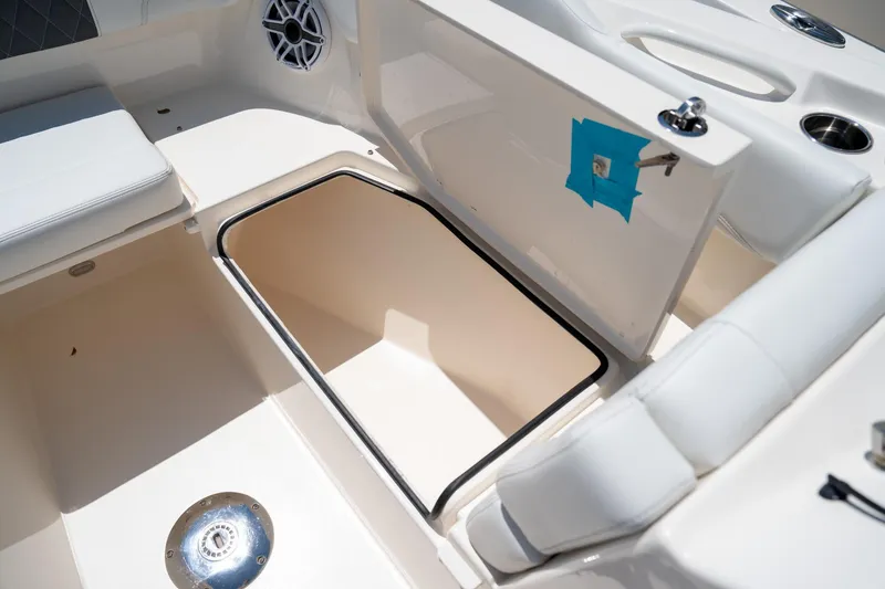 Slide: The Image of 2024 Cobia 280 DC boat interior storage compartment with seating and speaker. - 37